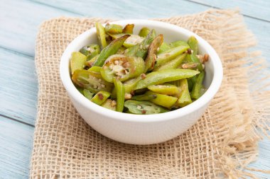 Izgara bamya, ahşap bir masada beyaz bir kasede, izole edilmiş.