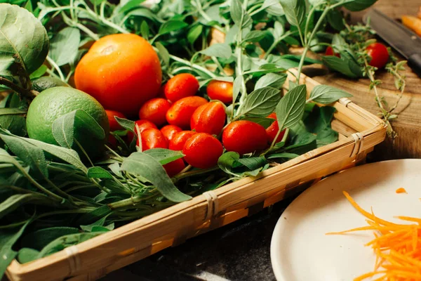 Organic vegetables in a basket, tomatoes and leaves