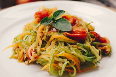 Vegan pasta, a sliced vegetable salad, zucchini, tomatoes and carrots