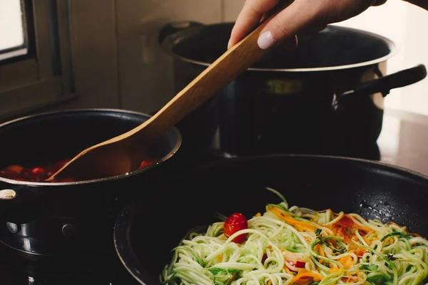 stock image Cooking tomatoes, grated carrot and zucchini on a pan, female hands, closed view