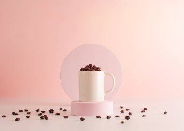 Pastel renkli arka planda, bir fincanda kavrulmuş kahve çekirdeği.