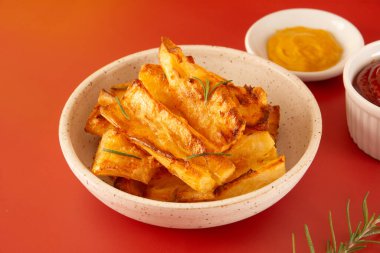 Kırmızı Stüdyo Arkaplanda Ketçap ve hardallı Beyaz Seramik Kasede Lezzetli Kızarmış Cassava