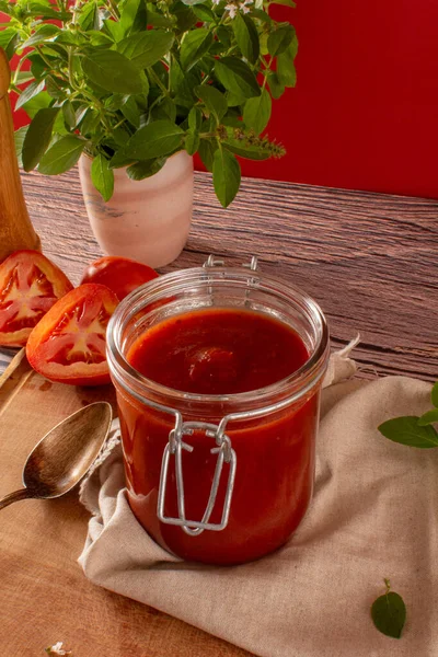 Salsa Pomodoro Fresco Barattolo Vetro Tavolo Legno Uno Sfondo Rosso — Foto Stock