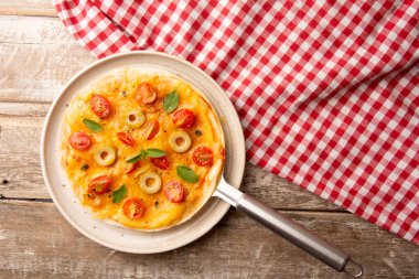 Domatesli pizza ve peynirli el yapımı seramik tabakta en üstte.