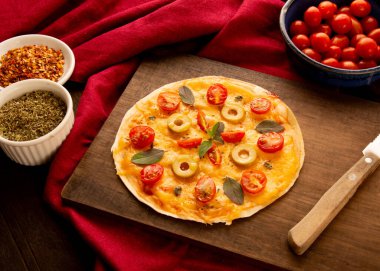 Domatesli, fesleğenli ve zeytinli ev yapımı pizza tavası.