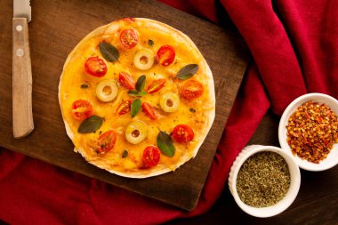 Domatesli, fesleğenli ve zeytinli ev yapımı pizza tavası.