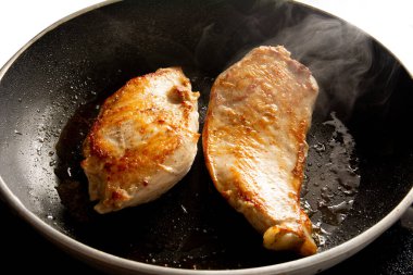 Tavada kızarmış tavuk var. Havadan bakıldığında siyah tavanın içinde.