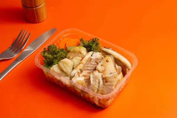 Healthy packed lunch box home prepared meal in clean orange background front view