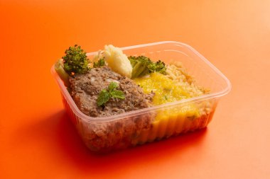 Sağlıklı paketlenmiş beslenme çantası hazır yemek ön tarafta temiz turuncu arka plan hava manzarası