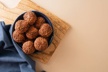 Çikolatalı yer mantarı topları Brigadeiro Brezilya şekeri ve çikolata taneleri hava görüşü bej arka plan
