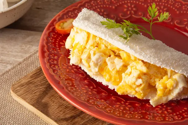 En öndeki kırmızı tabakta Brezilya usulü omletli Tapioca Pancake.