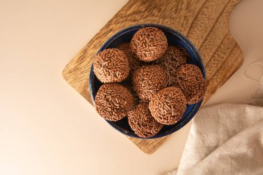 Çikolatalı yer mantarı topları Brigadeiro Brezilya şekeri ve çikolata taneleri hava görüşü bej arka plan