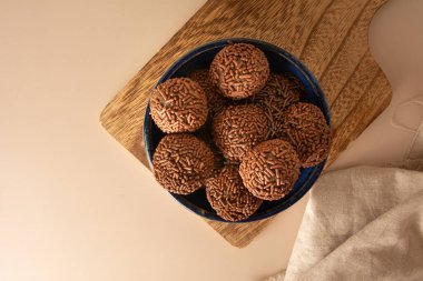 Çikolatalı yer mantarı topları Brigadeiro Brezilya şekeri ve çikolata taneleri hava görüşü bej arka plan