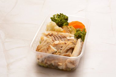 Sağlıklı balık beslenme çantasının önüne temiz bej arka plan koyar.