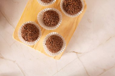 Çikolatalı yer mantarı Brigadeiro Brezilya parti şekerleri çikolata taneleri, hava manzaralı ahşap arka plan