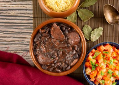 Brezilyalı Feijoada Domuz pastırmalı siyah fasulye güveci ve domuz sosisi kasesi.