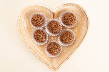 Brigadeiro çikolatalı yer mantarı topları. Üstünde de kağıt bir paketin içinde çikolata var.