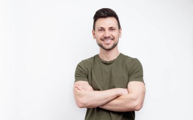 Beyaz arka planda çapraz kollu gülümseyen adam. Fitness eğitmeni