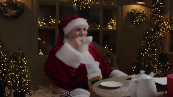 圣诞老人坐在后院 享受他的假期 休息和喝茶 享受舒适的夜晚 慢动作 — 图库视频影像