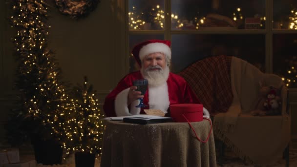 圣诞老人的画像 灰白胡子的老人 拿着杯酒 在镜头前装腔作势地笑着 祝大家圣诞快乐 过冬祝贺 动作缓慢 — 图库视频影像