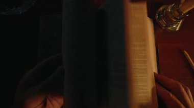 Bir inanan İncil 'i okuyor, kutsal kitabı araştırıyor, bir masanın üzerinde, yumuşak mum ışığında, günlük ruhani uygulamalar, yakın çekim, yüksek kalite 4K görüntü
