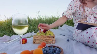 Taze meyve, şarap ve iyi bir arkadaş eşliğinde doğada keyifli ve huzurlu bir piknik yapıyorum.