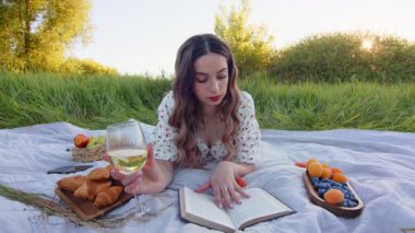 Bir bardak şarap ve çarpıcı bir açık hava ortamında büyüleyici bir kitapla huzurlu bir pikniğin tadını çıkarıyorum.