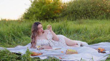 Genç bir kadın, doğanın çarpıcı manzarasıyla çevrili keyifli ve huzurlu bir pikniğin tadını çıkarıyor.