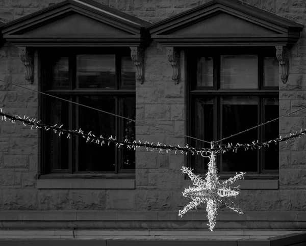 Christmas street decoration in front of large windows.