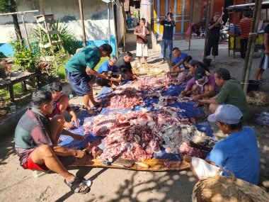 Tegal, INDONESIA, 10 Temmuz 2022 - Bir grup Endonezyalı, Kurban Bayramı kutlamalarında imkanları kısıtlı olanlara dağıtılmak üzere koyun eti kesiyor