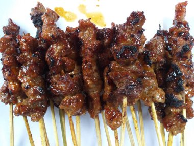 Beyaz bir tabakta pişmiş kuzu pirzolasının seçici odak noktası, yüksek açıyla çekilmiş.