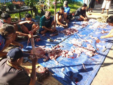 Tegal, INDONESIA, 10 Temmuz 2022 - Bir grup Endonezyalı Kurban Bayramı kutlamalarında çeşitli keçi eti kesme görevini paylaşıyor