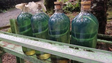 Yeşil metal rafta benzin şişeleri var. Çevre ya da yakıt endüstrisi kavramları. Tehlikeli madde deposu ya da ulaşım görüntüleri. Enerji temaları.