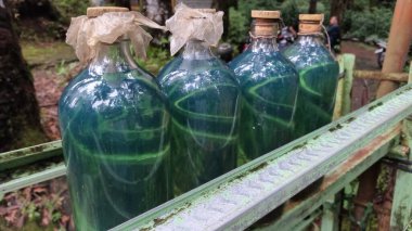 Paslı metal bir rafta benzin şişeleri. Yakıt endüstrisi sunumları, çevresel makaleler veya endüstriyel temalı tasarım projeleri için mükemmel.