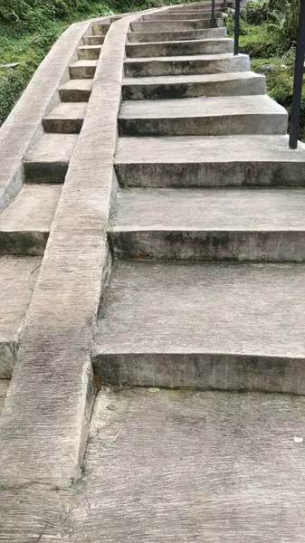 Somut adımlar yemyeşil bitki örtüsünün arasında yukarı doğru çıkarak davetkar ve uyumlu bir açık hava ortamı yaratır. Peyzaj, doğa ya da yaşam tarzı temaları için ideal.