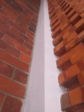 Bir köşede buluşan iki tuğla duvarın portresi mimari tasarım projeleri, kentsel altyapılar ve inşa temalı sunumlar için mükemmel..