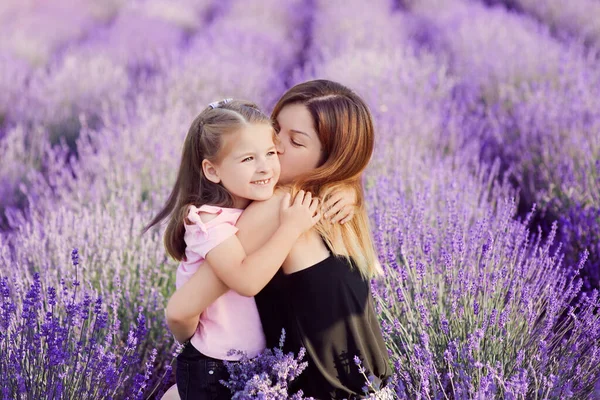 白人母亲在薰衣草地里亲吻和拥抱她的女儿 — 图库照片
