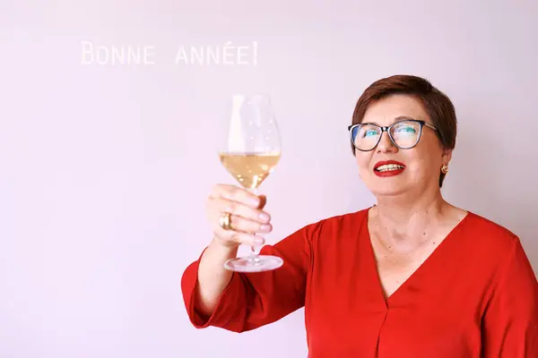 新年を祝う白ワインのガラスと赤ブラウスでスタイリッシュな成熟したシニア女性 楽しい パーティー スタイル ライフスタイル アルコール お祝いのコンセプト — ストック写真