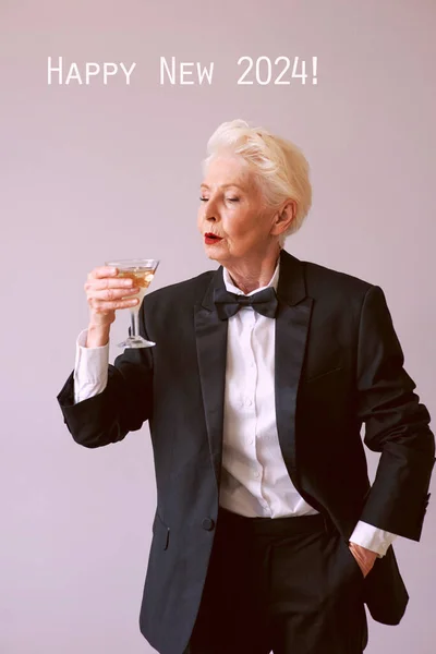 时尚成熟的老年女子在燕尾服与一杯闪亮的葡萄酒庆祝新年 生活方式 庆祝概念 — 图库照片