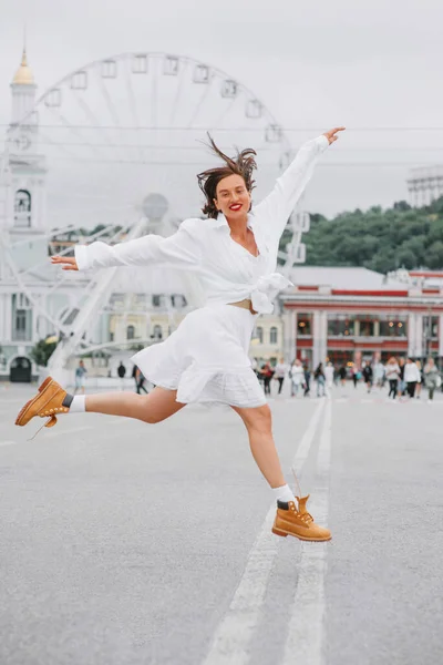 Счастливая Женщина Белом Платье Прыгает Городской Площади Колесом Обозрения Заднем Стоковая Картинка