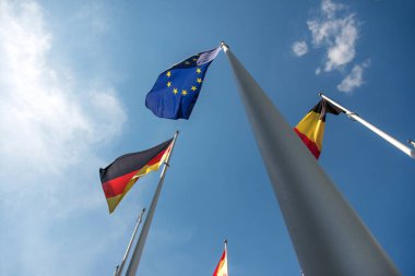 Avrupa Birliği, Almanya ve Belçika bayrakları rüzgarda dalgalanıyor.