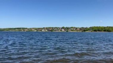 Yazın sonlarında mavi bir gölün kıyısındaki ağaçlar. Yüksek kalite 4K görüntü. Seyahat, yaşam tarzı, turizm, gayrimenkul ve emeklilik içeriği. Güzel doğa manzarası. Sakin bir göle bak.. 