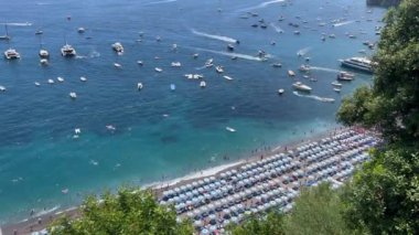Positano ve tekneler, İtalya. Akdeniz 'de tekneler ve yatlar. Positano 'daki Tyrhenian deniz kıyısının manzarası. Suda bir sürü tekne var. Positano 'nun manzarası harika. İtalya 'nın en iyi tatil beldeleri 