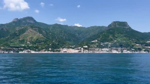 ティレニア海によるロッキー崖と山の風景 イタリアのアマルフィ海岸 自然背景 アマルフィ海岸はヨーロッパで最も人気のある旅行と休暇の目的地です アマルフィ付近でヨットが進行中 — ストック動画