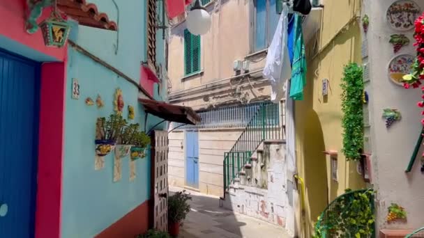 色の家の狭い通りに表示 市内の伝統的な陶器の装飾とベトナム領事マーレ Amalfi海岸 イタリア イタリアのカンパニア州にあるVietri Sul Mareにカラフルな家や通り — ストック動画