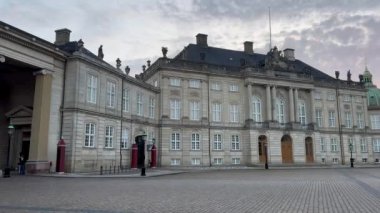 Bir sarayın ön cephesi, Amalienborg Sarayı, Kopenhag, Danimarka. Amalienborg 17. yüzyılda inşa edildi ve Danimarka 'nın en etkileyici rokoko binalarından biridir. Kalabalıksız kale meydanının tadını çıkar..