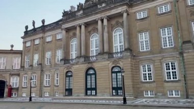 Bir sarayın ön cephesi, Amalienborg Sarayı, Kopenhag, Danimarka. Amalienborg 17. yüzyılda inşa edildi ve Danimarka 'nın en etkileyici rokoko binalarından biridir. Kalabalıksız kale meydanının tadını çıkar..