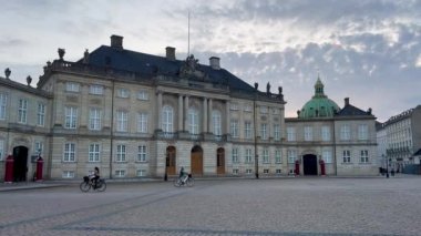 Bir sarayın ön cephesi, Amalienborg Sarayı, Kopenhag, Danimarka. Amalienborg 17. yüzyılda inşa edildi ve Danimarka 'nın en etkileyici rokoko binalarından biridir. Kalabalıksız kale meydanının tadını çıkar..