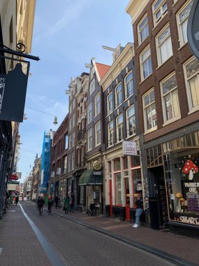 Amsterdam şehir merkezi - Amstel nehri, eski evler ve bir köprü. Meşhur Amsterdam şehrinin güzel manzarası. Avrupa 'ya seyahat. Hollanda, Hollanda. Geleneksel Hollanda eski evleri. Amsterdam Bisikletleri 