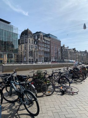 Amsterdam şehir merkezi - Amstel nehri, eski evler ve bir köprü. Meşhur Amsterdam şehrinin güzel manzarası. Avrupa 'ya seyahat. Hollanda, Hollanda. Geleneksel Hollanda eski evleri. Amsterdam Bisikletleri 